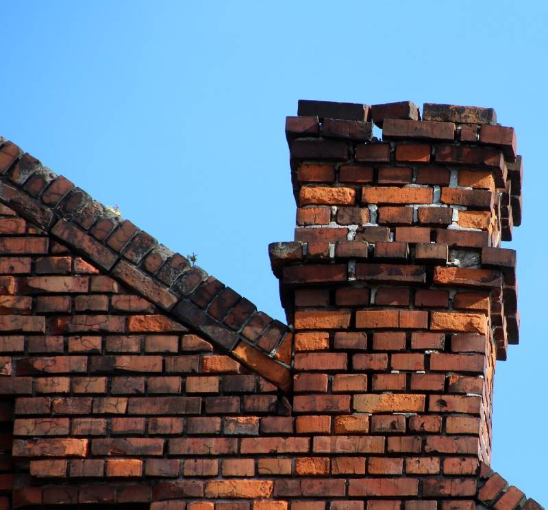 Signs Your Wilmington Home Needs a Chimney Inspection Damaged chimney on an Wilmington home showing cracks and missing mortar